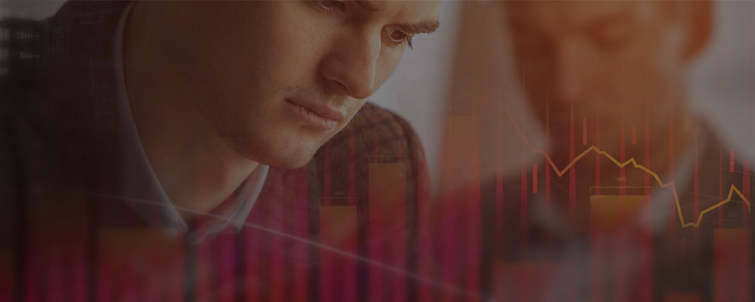 Two businessmen look down, overlaid with a red bar chart and a declining line graph